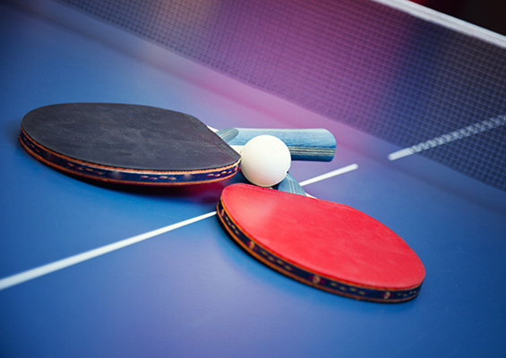Red and blue ping pong paddles on a ping pong table
